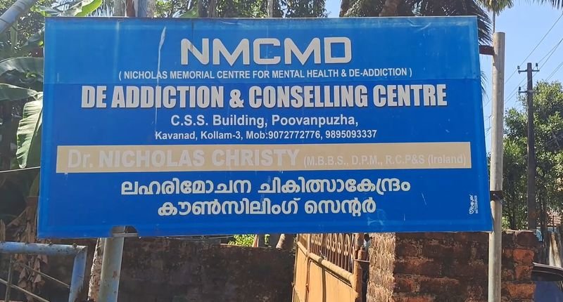 Close view of the blue NMCMD signboard with the centre name, address and phone numbers