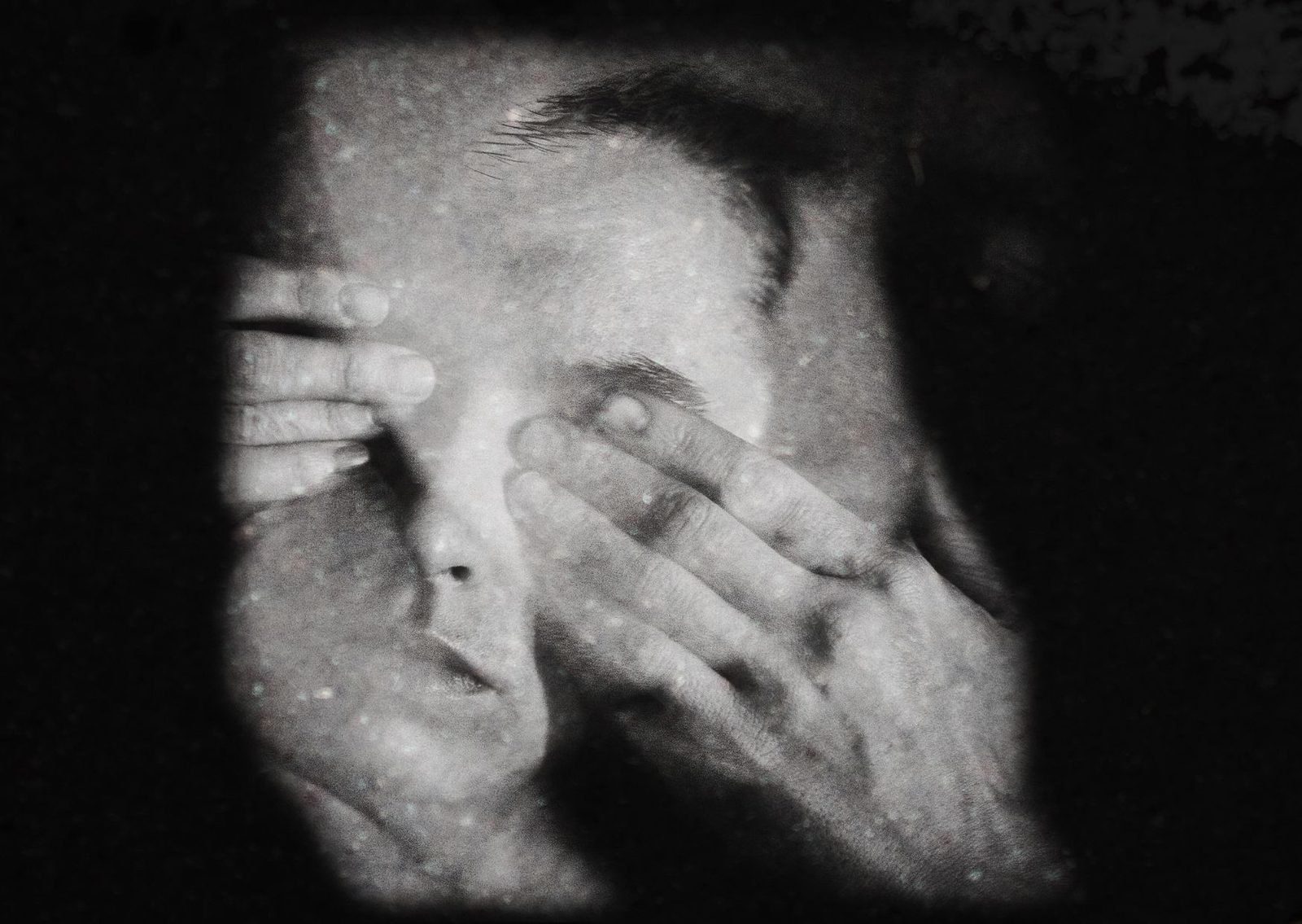 A man pressing his hands to his face in distress